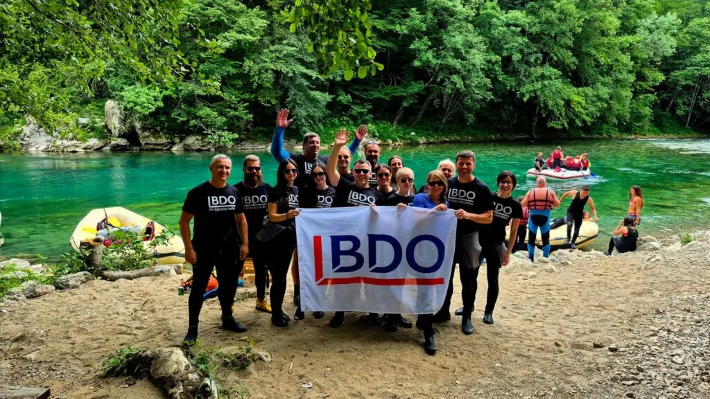 BDO tim sa zastavom uz rijeku