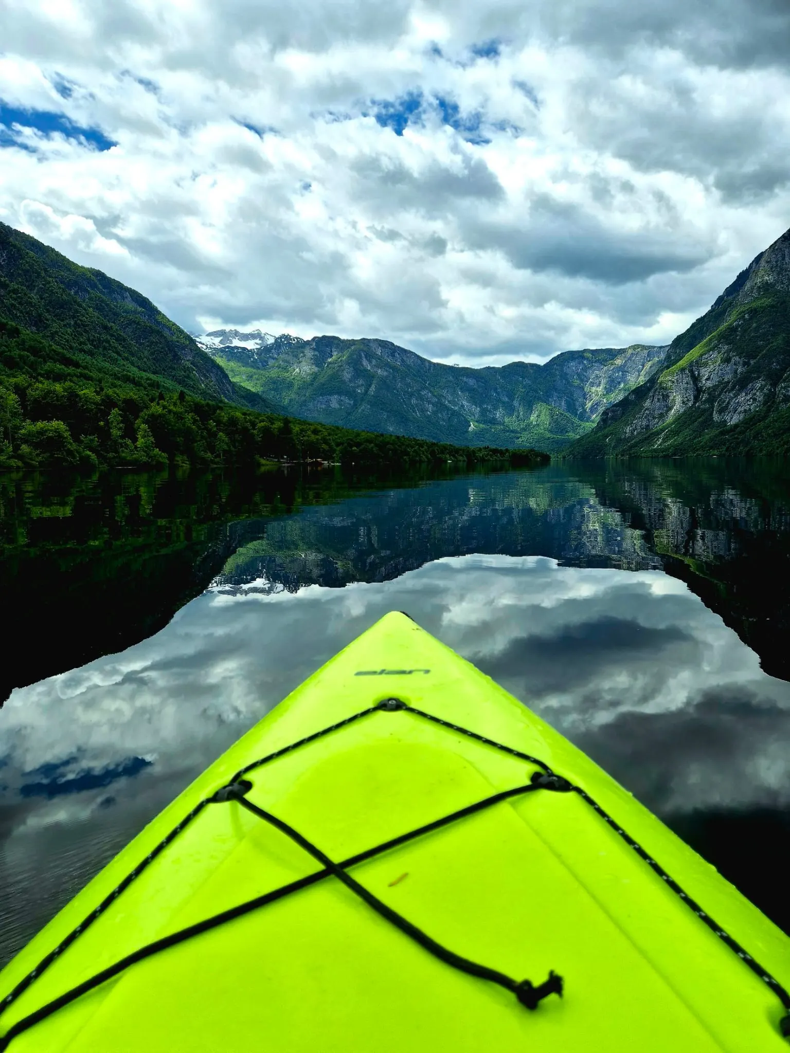 Pogled iz kajaka na mirno jezero i planine